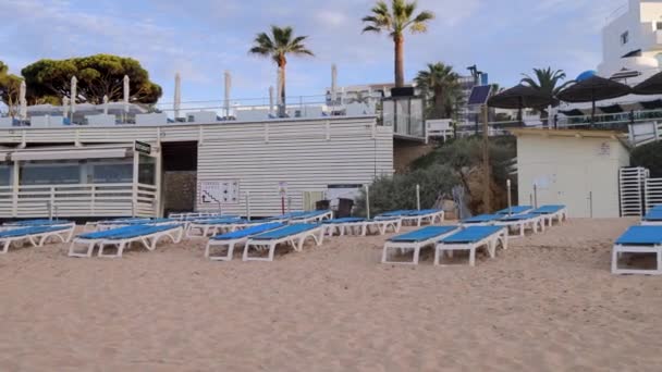 ポルトガルのアルブフェイラの美しいビーチフロントの映像は 晴れた夏の日に金色の砂浜にプライア オラのビーチブルーと白い日光を示しています — ストック動画