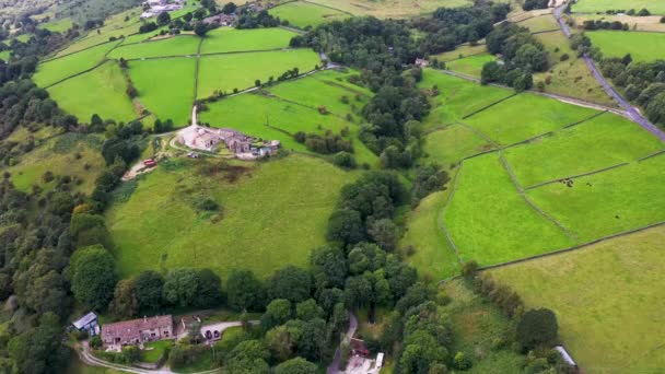 イギリスのキーリー ブラッドフォードの美しい村の航空無人機の映像は 夏の晴れた日に緑の畑に沿って農民の畑や農村の家を示しています — ストック動画