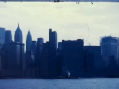 1973 'ten bu yana New York City' de çekilen son derece eski sinemalı film görüntüleri, kulelerin tepesinde hala inşaat çalışmaları devam eden ünlü İkiz Kuleler Dünya Ticaret Merkezleri 'ni gösteriyor..