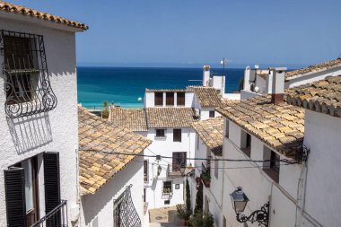 İspanya 'daki güzel Altea şehrinin fotoğrafı güneşli bir yaz gününde İspanyol evlerinden ve sokaklarından okyanus manzarasını gösteriyor.