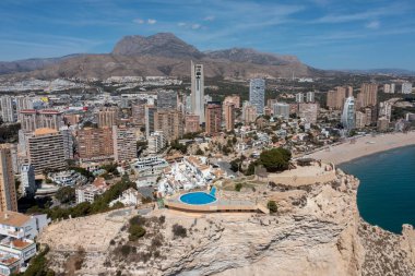 İspanya 'nın Benidorm şehrinin yazın çekilmiş görüntüleri güneşli bir günde yüksek katlı daireleri ve batı sahili boyunca inşa edilen uzun sahili gösteriyor.