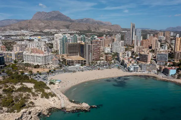 stock image Aerial drone photo of the town of Benidorm in Spain in the summer time showing the beach known locally as Playa de Finestrat and hotels and apartments around the small beach