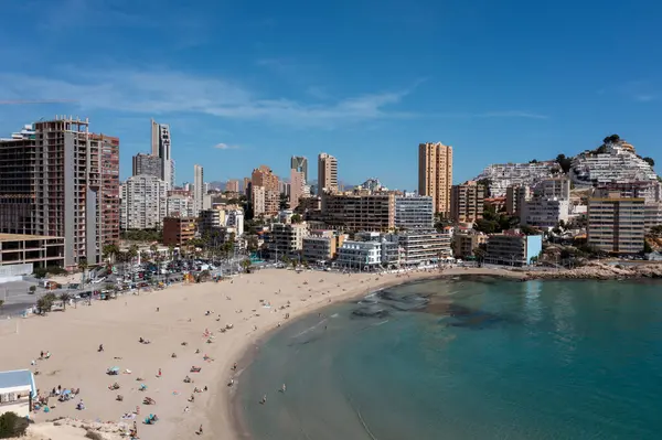 stock image Aerial drone photo of the town of Benidorm in Spain in the summer time showing the beach known locally as Playa de Finestrat and hotels and apartments around the small beach