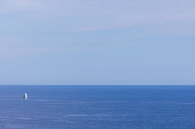 Güneşli bir yaz gününde İspanya 'nın Benidorm şehrinde açık mavi bir gökyüzünde çekilmiş bir yelkenli resmi.