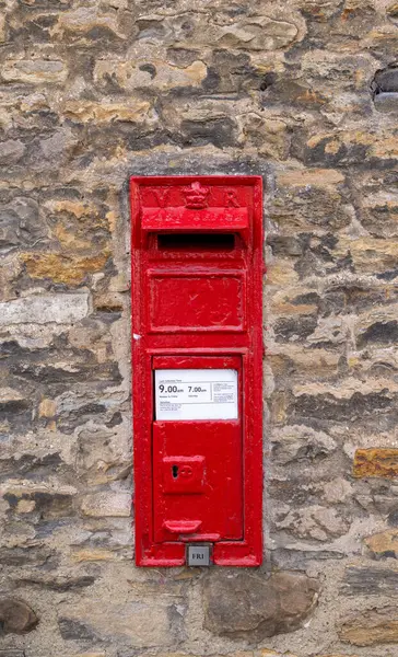 Kuzey Yorkshire, İngiltere 'de bir pazar kasabası olan güzel Richmond kasabasının fotoğrafı. Duvara monte edilmiş eski bir İngiliz Posta Postası' nı gösteriyor.