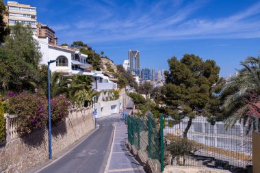 İspanya 'daki Benidorm kasabasının fotoğrafı arka planda yüksek binaların bulunduğu sahile giden bir yol olduğunu gösteriyor.