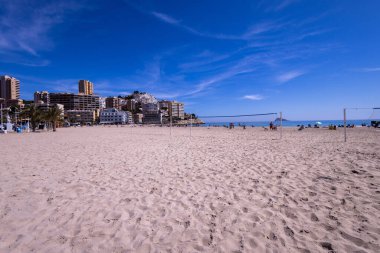 Yazın İspanya 'nın Benidorm kasabasının fotoğrafı Playa de Finestrat olarak bilinen plajı ve kumsalda voleybol topunu gösteriyor.