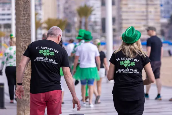 stock image Benidorm Spain, 17th March 2024: Photo of the town on Benidorm in Spain showing people celebrating St Patricks day in the sun shine on the beach front on a sunny day in the summer.