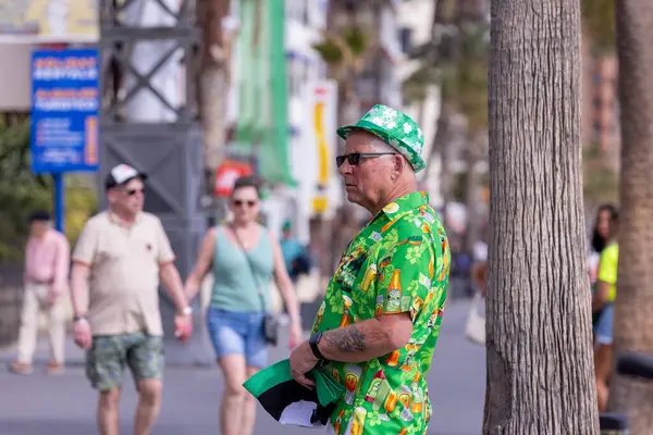 stock image Benidorm Spain, 17th March 2024: Photo of the town on Benidorm in Spain showing people celebrating St Patricks day in the sun shine on the beach front on a sunny day in the summer.