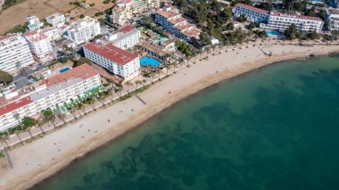 İbiza 'nın güzel şehri Sant Antoni de Portmany' de havadan çekilmiş bir fotoğraf. Playa de San Antonio olarak bilinen plajı gösteriyor. Yazın kumsalda dinlenen insanlar.