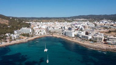 İbiza Balearic Adaları 'ndaki Sant Antoni de Portmany kasabasındaki bir kumsalın insansız hava aracı fotoğrafı İspanya' nın okyanus cephesini ve Cala Alto de Porta plajını gösteriyor..