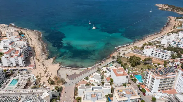 İbiza Balearic Adaları 'ndaki Sant Antoni de Portmany kasabasındaki bir kumsalın insansız hava aracı fotoğrafı İspanya' nın okyanus cephesini ve Cala Alto de Porta plajını gösteriyor..