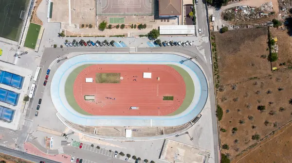 stock image Aerial drone photo of a sports stadium in the town of Sant Antoni de Portmany on the island of Ibiza in the Balearic Islands Spain, showing the running track stadium in the summer time.