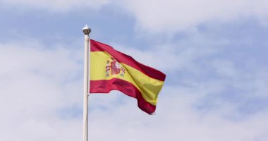 Güneşli bir yaz gününde rüzgarda dalgalanan İspanyol bayrağının yavaş çekim görüntüleri.