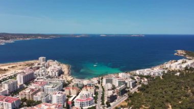İbiza 'nın batı kıyısındaki Sant Antoni de Portmany kasabasının insansız hava aracı görüntüleri, Spains Balear Adalarından biri, yaz aylarında şehir merkezindeki otellerin yanındaki okyanus cephesini gösteriyor..