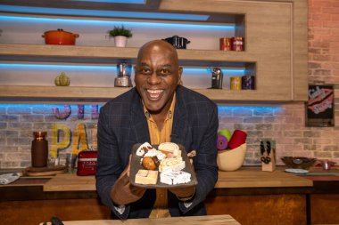 Leeds UK, 21 Eylül 2020: İngiliz TV sunucusu ve Şef Ainsley Harriott Leeds West Yorkshire 'da canlı yayında ellerinde bir tepsi pasta tutuyorlar.