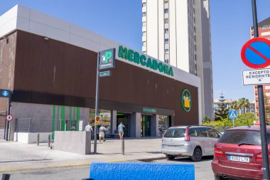 Benidorm İspanya, 3 Haziran 2024: İspanya 'daki Benidorm şehrinin fotoğrafı, Mercadona' daki ünlü süpermarket binasını ve arabaları yazın şehir merkezinde park halinde gösteriyor.