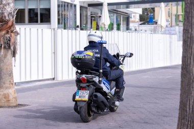 Benidorm İspanya, 17 Mart 2024: İspanya 'da Benidorm' da çekilen fotoğraf, güneşli bir yaz gününde plaj cephesinde Aziz Patrick Günü 'nü kutlayan insanları gösteriyor..