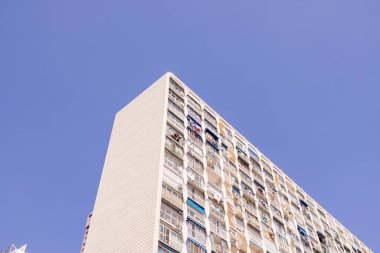 İspanya 'nın Benidorm şehrindeki bir apartman bloğunda çekilmiş bir fotoğraf. Güneşli bir yaz gününde kuruyacak kıyafetleri olan apartman pencerelerini gösteriyor.