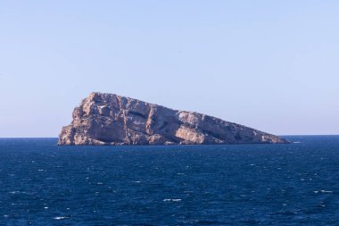İspanya 'daki Benidorm kasabasının fotoğrafı açık bir yaz gününde Benidorm Adası veya Mirador de l' Illa de Benidorm olarak bilinen okyanusun ortasındaki kayayı gösteriyor.