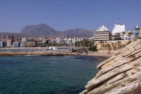 stock image Photo of the beautiful city of Benidorm in Spain showing the busy Cala del Mal Pas beach with people on the beach relaxing and sunbathing on vacation in the summer