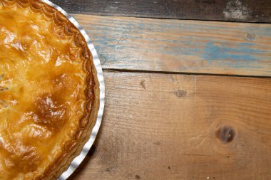 Lezzetli pişmiş etli turta ahşap mutfak masasında leziz et turtası ve kabuğu gösterir.