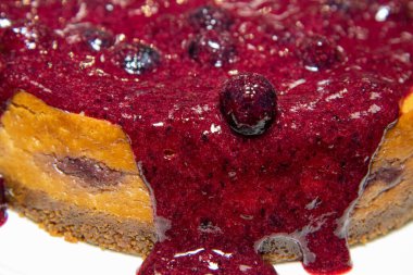 Lezzetli bir yaban mersini ve zencefilli bisküvili peynirli keki beyaz tabakta yakın.