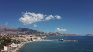 İspanya 'nın L' Albir kasabasının güneşli bir yaz gününde kumsal cephesini gösteren hava aracı görüntüleri ve okyanusa çok yakın bir yere inen insansız hava aracı.