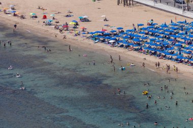 Benidorm İspanya, 14 Temmuz 2024: İspanya 'nın Benidorm şehrinin yazın çekilen fotoğrafı, insanları ünlü Levante Sahili' nde ve çocukların okyanustaki şişme tablolarında gösteriyor.