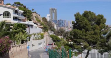 İspanya 'nın Benidorm kentinin yaz ayındaki görüntüleri, tipik bir İspanyol caddesinden Batı Sahili Gezinti Güvertesine uzanan yüksek katlı apartman ve binaları gösteriyor.