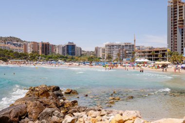 Benidorm Spain, 17th June 2024: Photo of the city of Benidorm in Spain in the summer time showing the beach known locally as Playa de Finestrat and hotels and apartments around the small beach clipart