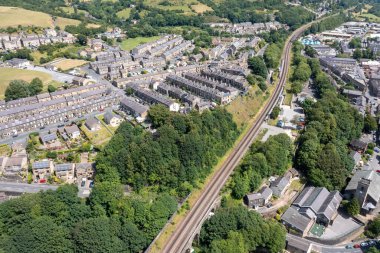 İngiltere 'nin tarihi Yorkshire kasabası Huddersfield' ın havadan çekilmiş fotoğrafı güneşli bir yaz gününde şehir içindeki yerleşim yerlerini ve tren raylarını gösteriyor.