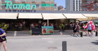 Benidorm İspanya, 29 Mayıs 2024: İspanya 'da Benidorm şehrinin ana cadde ve restoranlarını gösteren görüntüler yaz mevsiminin güneşli bir gününde sahilin karşısında.