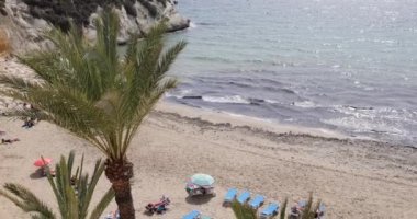 Güzel Benidorm kasabasının, yaz mevsiminin güneşli bir yaz gününde kumlu sahilde güneşlenen insanlarla dolu kayık limanında Cala del Mal Pas Plajı 'nı gösteren görüntüsü.