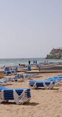 Benidorm İspanya, 15 Mart 2024: İspanya 'nın Benidorm kentinin yazın çekilen portre görüntüleri Levante Sahili boyunca turistlerin ve insanların yürüdüğü yolu gösteriyor