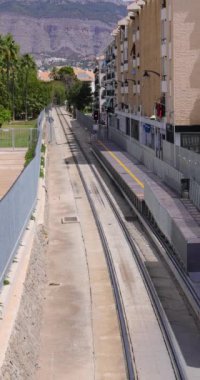 İspanya 'daki Altea kasabasının, yaz aylarında şehir merkezinde bir tren rayını gösteren portre görüntüleri.