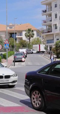 Altea, Alicante, İspanya, 20 Nisan 2024: İspanya 'daki Altea kasabasının trafik ve yaz mevsiminde karşıya geçen insanları gösteren portre görüntüleri