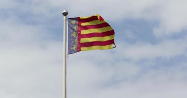 Valencia Topluluğu bayrağının açık havada rüzgarda dalgalandığı yavaş çekim görüntüleri. Valencia Topluluğu İspanya 'nın özerk bir topluluğudur.