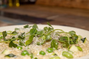 Ahşap mutfak masasında nefis bir kabak, fasulye ve bezelye pilavı.