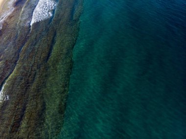 İspanya 'nın Benidorm kasabasında çekilen güzel plajın havadan çekilmiş fotoğrafı tipik bir İspanyol plajının üst manzarasını gösteriyor.