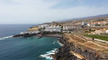 Costa Adeje, Santa Cruz de Tenerife 'nin hava aracı görüntüleri, Playa de Ajabo plajını siyah kumları, otelleri ve kasabadaki iş yerlerini gösteriyor.