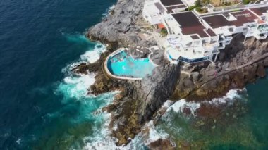 Costa Adeje, Santa Cruz de Tenerife 'nin güzel hava aracı görüntüleri okyanus kıyısında terk edilmiş eski yüzme havuzunu ve Playa de Ajabo plajını gösteriyor..