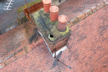 Aerial photo of a typical British terrace house in the UK showing the roof of the house and the chimney in the winter time clipart