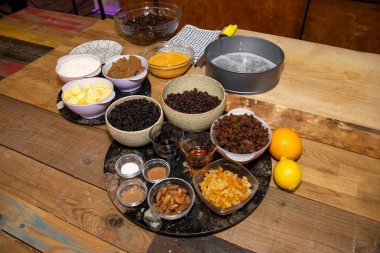 Ahşap mutfak kapağında meyveli bir Noel pastasının malzemeleri.