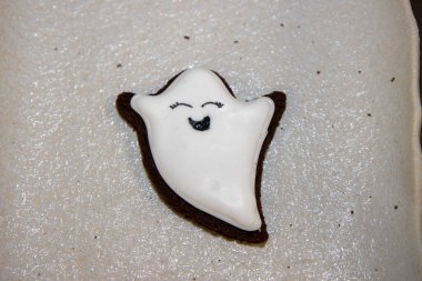 Hayalet şeklinde bir cadılar bayramı kurabiyesi ya da beyaz kremalı ve gülümseyen yüzlü bir üçlüde gulyabani.