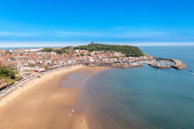 İngiltere 'nin güzel sahil kasabası Scarborough' un güneşli bir yaz gününde kumsal cephesini gösteren hava fotoğrafı.