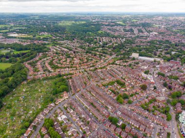 Aerial photo over looking the area of Leeds known as Headingley in West Yorkshire UK, showing a typical British hosing estate with fields and roads taken with a drone on a sunny day clipart