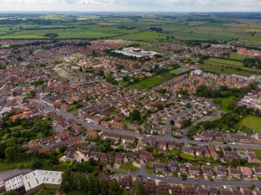 İngiltere 'nin Kuzey Yorkshire kentindeki York kentinin hava fotoğrafı, tipik İngiliz yerleşim yerlerinde, parçalı bulutlu bir yaz gününde yol kenarındaki ev ve caddeleri gösteriyor.