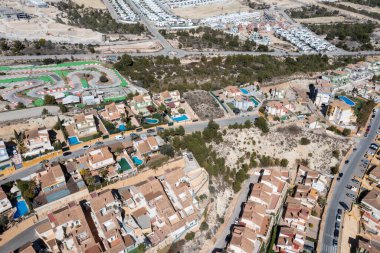 İspanya 'nın Benidorm şehrinin yaz mevsiminde çekilen insansız hava aracı fotoğrafı yazın güneşli bir günde Finestrat kasabasındaki evleri ve İspanyol villalarını gösteriyor.