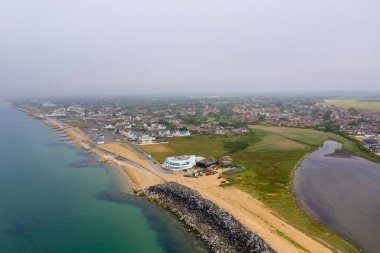 Bournemouth 'un güney sahilindeki hava aracı fotoğrafı çok bulutlu bir günde okyanus kıyısında alçak seviye bulutlar gösteriyor.